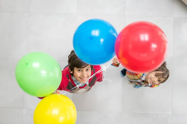 Vista dall'alto di due fratelli che giocano con i palloncini — Foto Stock