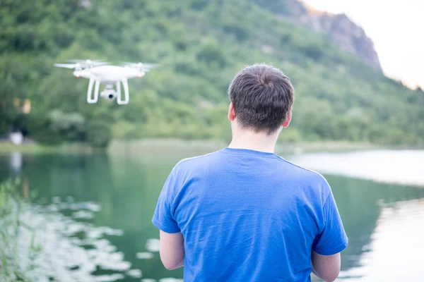 Homem na natureza controlando drone voando — Fotografia de Stock