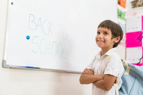 Menino escrevendo no quadro branco de volta à escola — Fotografia de Stock