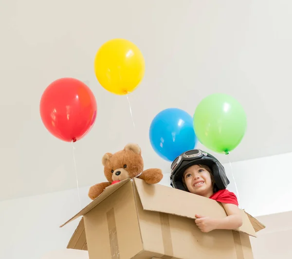 Boldog fiú ül a dobozában elképzelni őt önálló repülő — Stock Fotó