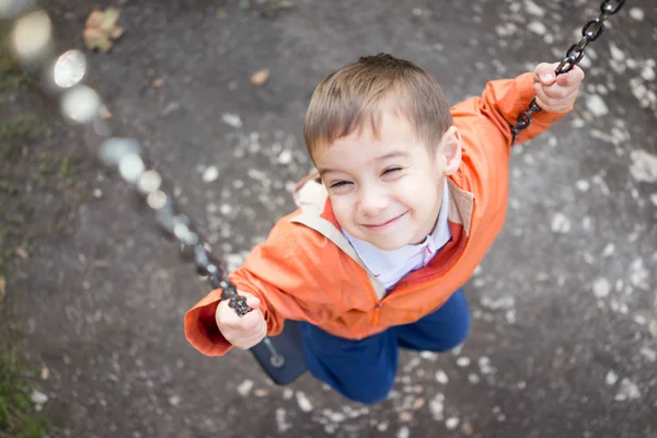 Menino no parque no balanço — Fotografia de Stock