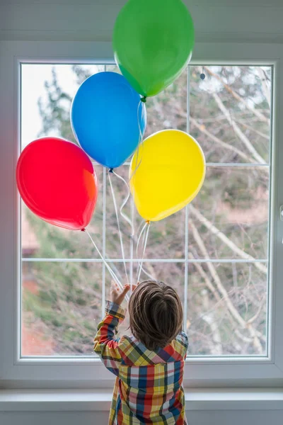 Ragazzo con palloncini davanti alla finestra — Foto Stock