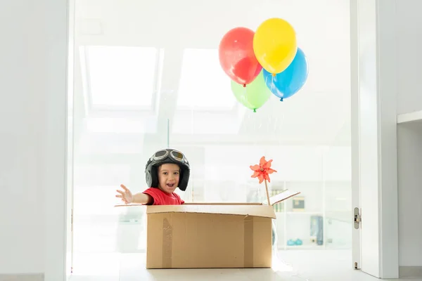 Glücklicher Junge, der in seiner Box sitzt und sich vorstellt, er fliege selbst — Stockfoto