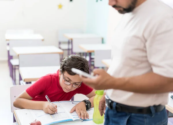 Niño en el aula de la escuela con maestro musulmán — Foto de Stock