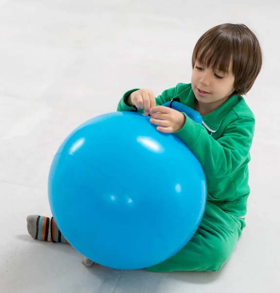 Αγόρι που παίζει και αγκαλιάζει μια μεγάλη μπάλα — Φωτογραφία Αρχείου