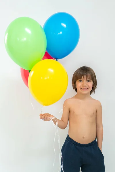 Garçon appréciant un tas de ballons — Photo