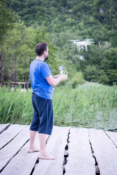 Homem na natureza controlando drone voando — Fotografia de Stock