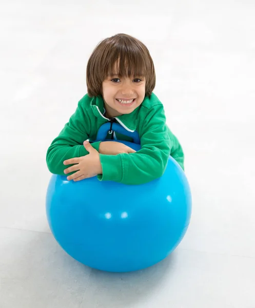 Menino jogando e abraçando uma grande bola — Fotografia de Stock