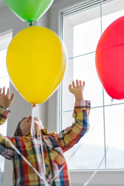 Boy with balloons in front of window — Stok fotoğraf
