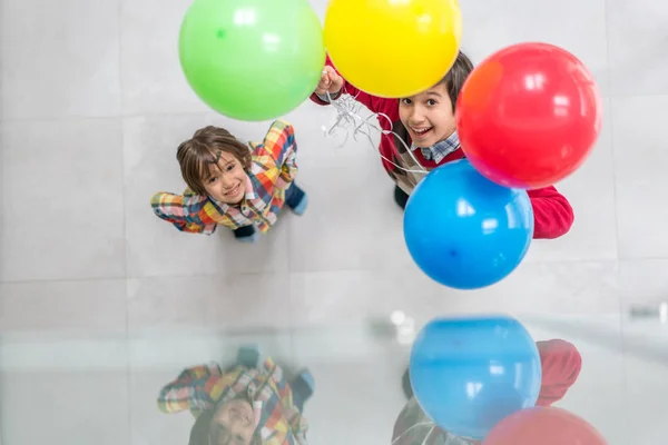 Nejlepší pohled na dva bratry, jak si hrají s balónky — Stock fotografie