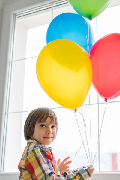 Chlapec s balónky před oknem — Stock fotografie