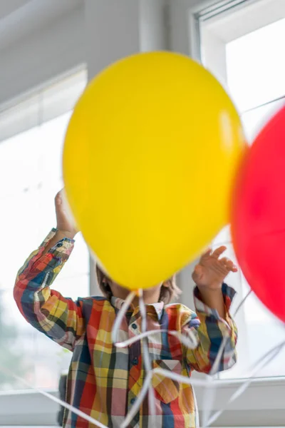 Boy with balloons in front of window — Stock Photo, Image