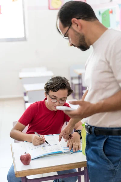 Niño en el aula de la escuela con maestro musulmán — Foto de Stock