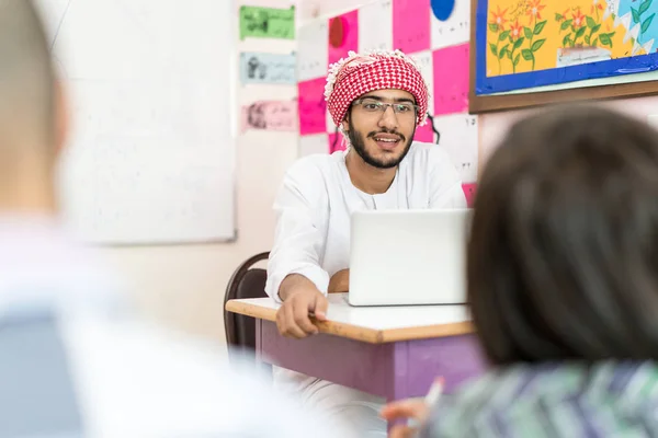 Dziecko w szkolnej klasie z nauczycielem muzułmańskim — Zdjęcie stockowe