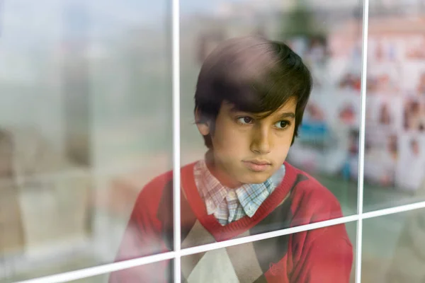 Rapaz feliz atrás do vidro da janela — Fotografia de Stock