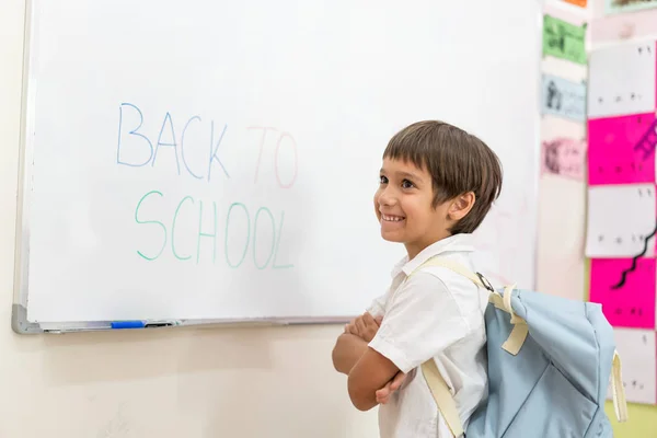Мальчик пишет на доске Вернуться в школу — стоковое фото