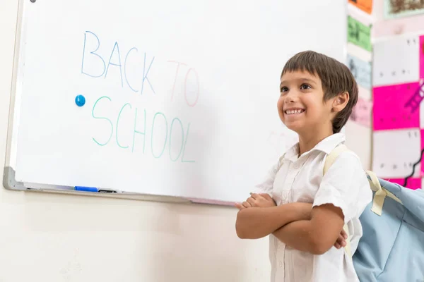 Menino escrevendo no quadro branco de volta à escola — Fotografia de Stock