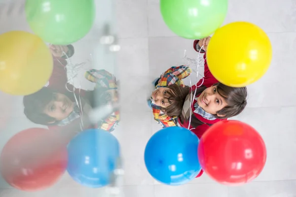 Balonlar ile oynayan iki kardeş üst görünümü — Stok fotoğraf