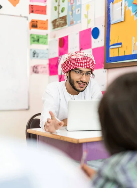 Child in school classroom with Muslim teacher — Stock Photo, Image
