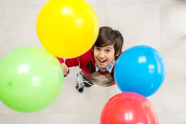 Вид сверху на мальчика с воздушными шарами — стоковое фото