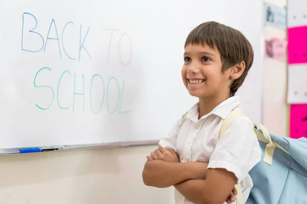 ホワイトボードに書いて学校に戻る少年 — ストック写真