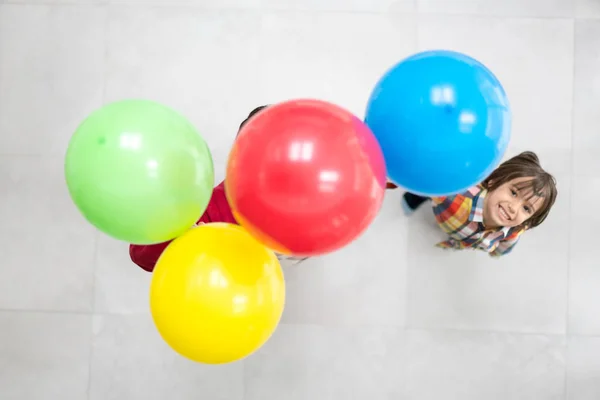 Vista superior de dos hermanos jugando con globos Imágenes de stock libres de derechos