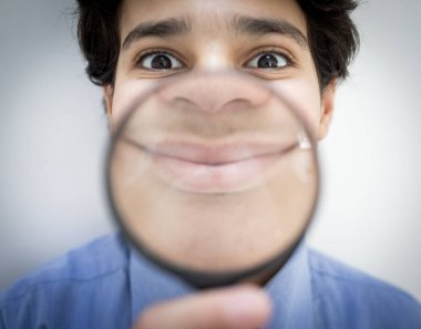 Büyüteçli genç çocuk