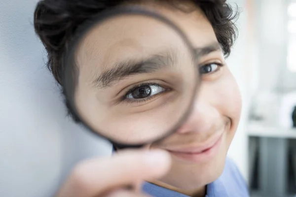 Teenage boy with magnifier — Stock Photo, Image