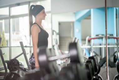 Siyahlı kadın GZM 'de dambıl kullanıyor.