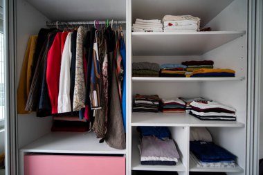 Oragniyed ve düzenli gardırop bir yatak odasında giysi ile