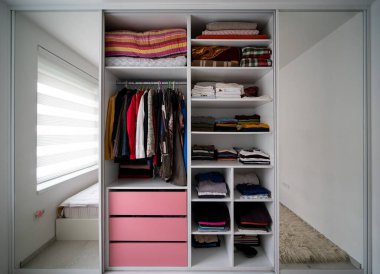 Oragniyed ve düzenli gardırop bir yatak odasında giysi ile