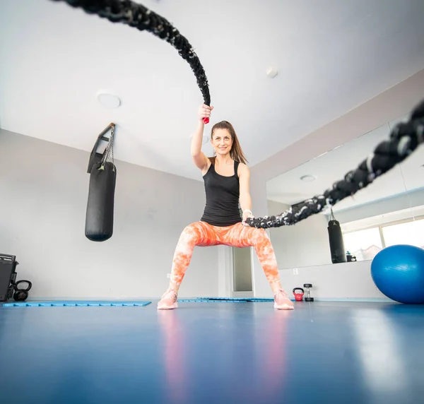 Attraktiv Fitte Frau Hockt Fitnessstudio Während Sie Seile Benutzt — Stockfoto