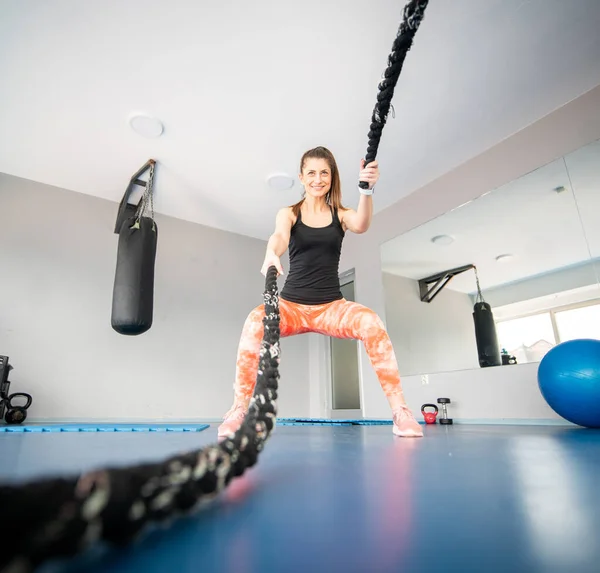 Atractiva Mujer Forma Cuclillas Mientras Usa Cuerdas Batalla Gimnasio — Foto de Stock