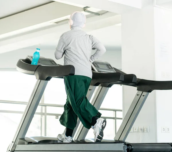 Spor Salonunda Koşu Bandında Kulaklıklı Müslüman Yetişkin Kadın — Stok fotoğraf