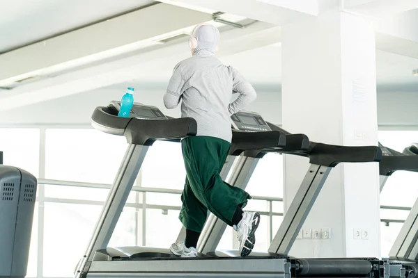 Spor Salonunda Koşu Bandında Kulaklıklı Müslüman Yetişkin Kadın — Stok fotoğraf