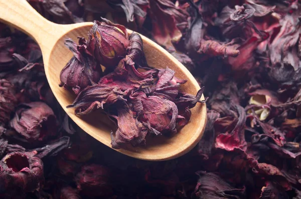 Top view of Dry Hibiscus petals in wooden spoon background close
