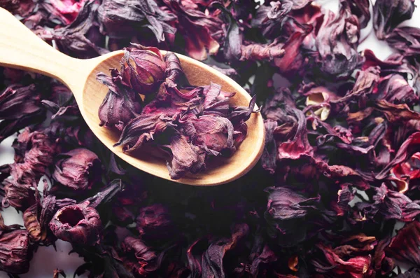 Top view of Dry Hibiscus petals in wooden spoon background close