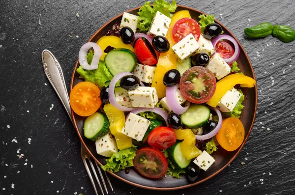 Top view at Mediterranean diet dish greek salad on slate tray