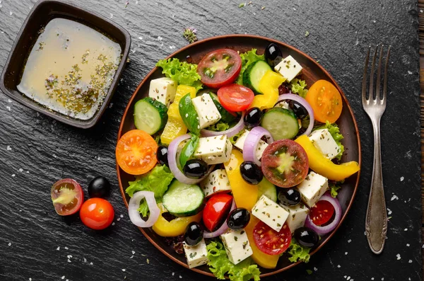 Top view at Mediterranean diet dish greek salad on slate tray wi