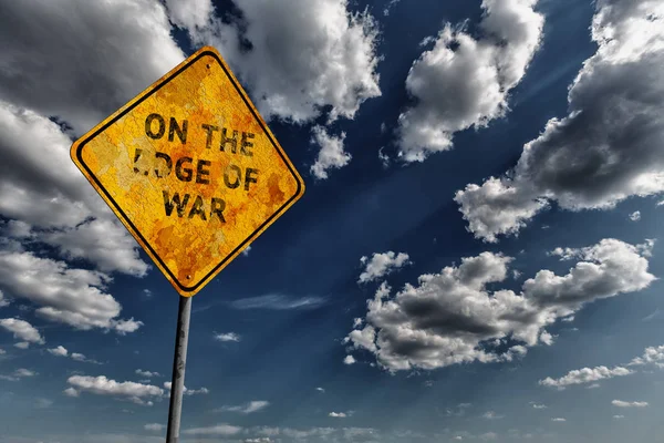 積雲と黄色の色あせた道路標識と戦争の端にテキストと暗い青空の背景 — ストック写真