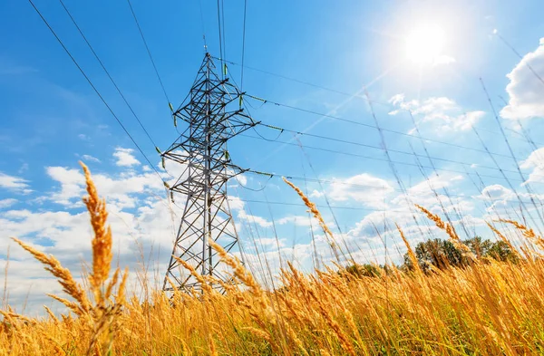 Hoogspanningslijn en blauwe hemel met zon — Stockfoto