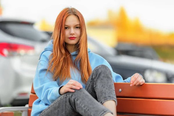 Smiling Teen Girl Hoodie Jeans Sitting Bench Looking Camera Shallow — Stock Photo, Image