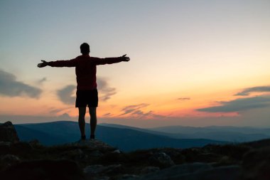 Adam dağ tepe on Sunset kutluyor. Bakarak görünümü ilham verici. Atlet, uzun yürüyüşe çıkan kimse ya da dağcı dağın zirveye ulaştığı trail, kayalık izinde Karkonosze, Polonya ilham verici manzara keyfini çıkarın