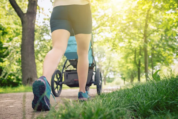 散步妇女与婴儿推车享受夏天在公园的一天 慢跑或动力行走超级妈妈 活跃的家庭与婴儿跑步 — 图库照片
