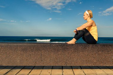 Kadın meditasyon Yoga poz, okyanus manzarası, plaj ve tahta kaldırım. Motivasyon ve ilham verici yaz deniz manzara. Açık havada doğa kavramı içinde sağlıklı yaşam tarzı.
