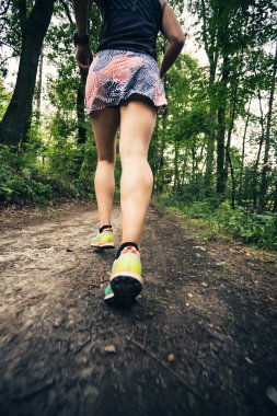 Atletik kadın çalışan yeşil orman, spor ilham ve motivasyon trail. Çapraz ülke çalışan kadın iz runner. Açık havada doğa içinde fitness kavramı.