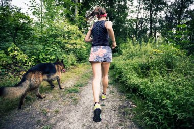 Atletik kadın çalışan yeşil orman, spor ilham ve motivasyon trail. Çapraz ülke çalışan kadın iz runner. Açık havada doğa içinde fitness kavramı.