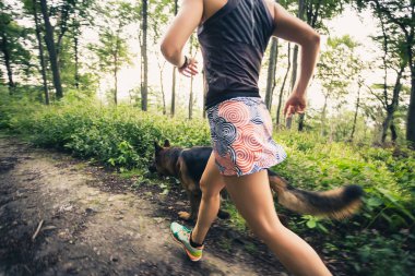 Atletik kadın çalışan yeşil orman, spor ilham ve motivasyon trail. Çapraz ülke çalışan kadın iz runner. Açık havada doğa içinde fitness kavramı.