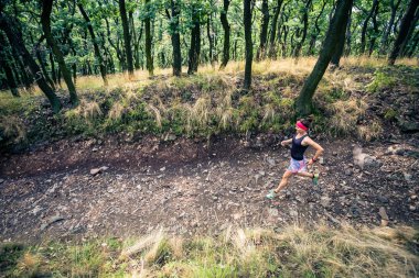 Atletik kadın çalışan yeşil orman, spor ilham ve motivasyon trail. Çapraz ülke çalışan kadın iz runner. Açık havada doğa içinde fitness kavramı.