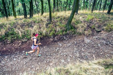 Atletik kadın çalışan yeşil orman, spor ilham ve motivasyon trail. Çapraz ülke çalışan kadın iz runner. Açık havada doğa içinde fitness kavramı.
